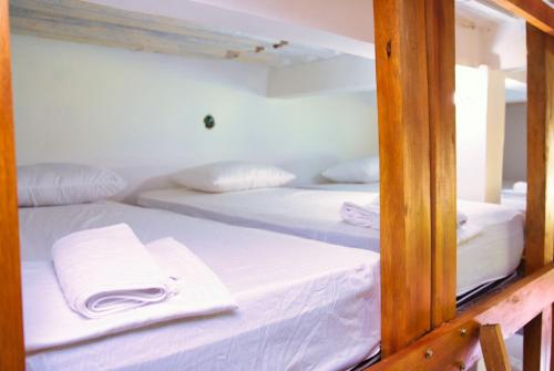 two beds in a room with a mirror at Hostal Sierra Quindío in El Fénix