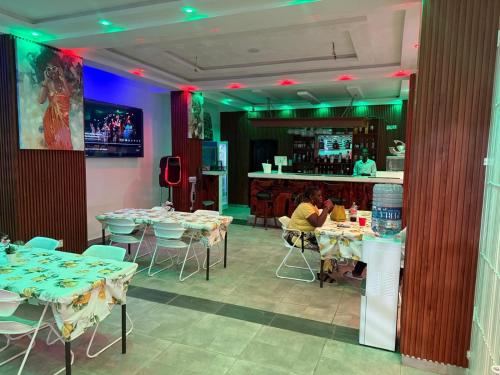 a restaurant with tables and chairs and a bar at Park Springs Hotel in Cape Coast