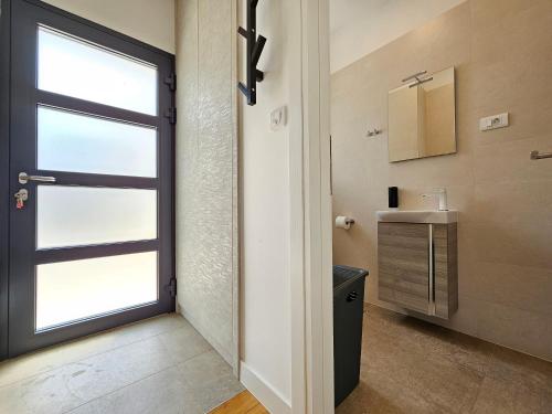 a bathroom with a window and a sink and a door at TI Amo Holiday House - Heated Pool in Kaštela