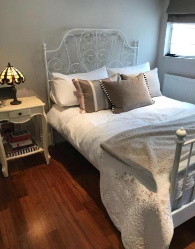 a bed with pillows on it in a bedroom at Beautiful Mews house just off Marylebone High St in London