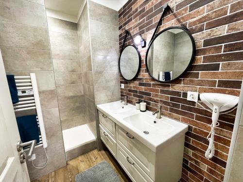 a bathroom with a sink and a brick wall at Comédie ST-Roch - T2 - Hypercentre Gare - CLIM & NETFLIX in Montpellier