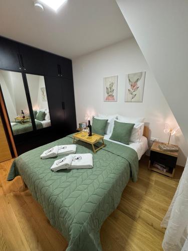 a bedroom with a bed with two towels on it at WOLF apartman in Divčibare