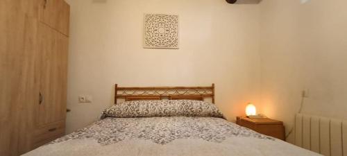 a bedroom with a bed and a lamp on a night stand at Alpujarra Casa Fortuna in Mecina Fondales