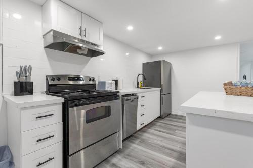 a kitchen with stainless steel appliances and white cabinets at Charming 2BR Near Niagara College in Welland