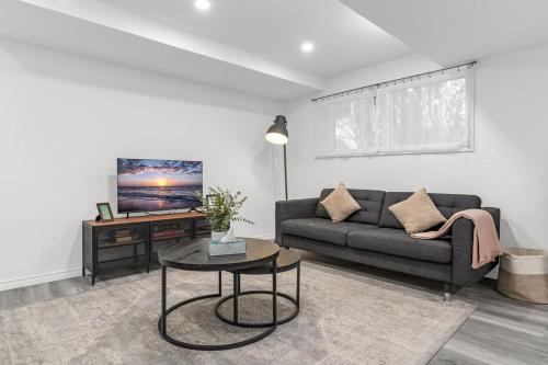 a living room with a couch and a table at Charming 2BR Near Niagara College in Welland