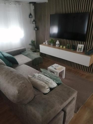 a living room with a couch and a flat screen tv at Tu hogar en Sevilla in Seville