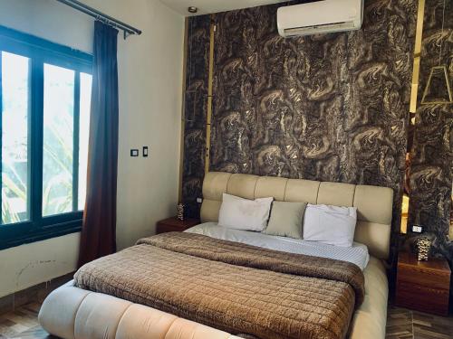 a bedroom with a large bed with a wall at TheIcon Boutique Villa Next to The Largest Museum in the World the Egyptian Grand museum in Sheikh Zayed