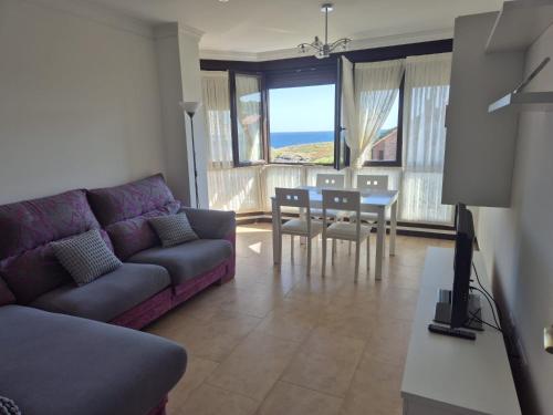 a living room with a purple couch and a table at Dúplex 3 habitaciones y 2 baños Fantásticas vistas in Noja
