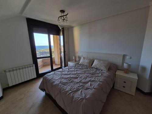 a bedroom with a large bed and a large window at Dúplex 3 habitaciones y 2 baños Fantásticas vistas in Noja