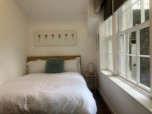a bedroom with a white bed and a window at Spacious Apartment in Central Edinburgh in Edinburgh