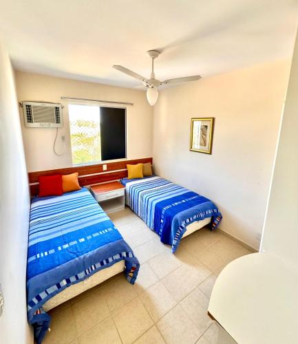 a room with two beds and a window at Apartamento 2 quartos em Rio Quente in Rio Quente