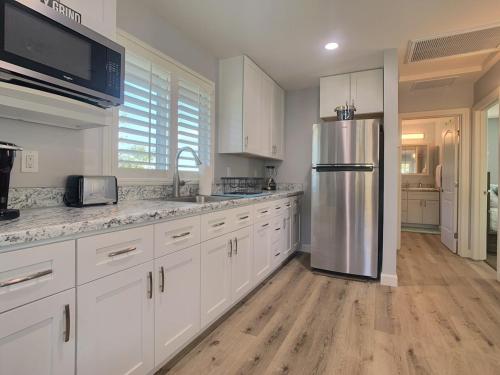 a kitchen with white cabinets and a stainless steel refrigerator at Alpine's Gorgeous Guest Home in Alpine