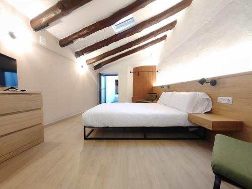 a bedroom with a large white bed and a television at Mazi Plaça Gran in Mataró