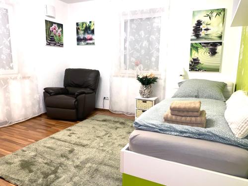 a small bedroom with a bed and a chair at FeWo Wagner in Dillingen an der Donau