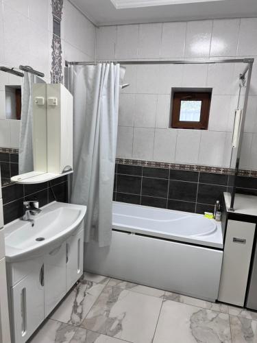 アルマトイにあるVilla de Saraの洗面台、浴槽、トイレを備えた白いバスルーム