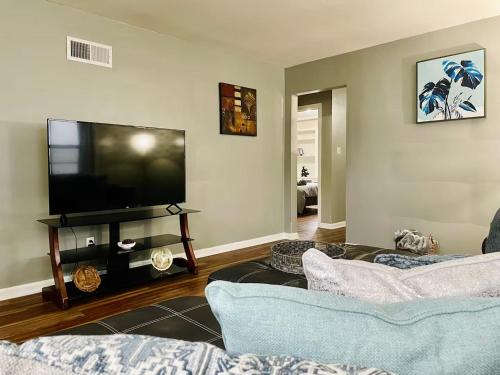 a living room with two couches and a flat screen tv at Central Chic on Washington in Evansville