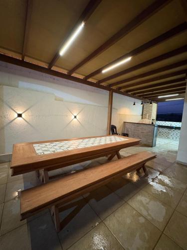 zwei Holzbänke unter einem Gebäude mit Lichtern in der Unterkunft Refúgio do Mel - Piscina e Forno a Lenha in Gravatá