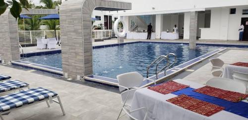 a swimming pool with a table and chairs next to it at Park Springs Hotel in Cape Coast