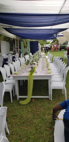 a long table with white chairs and a blue canopy at Park Springs Hotel in Cape Coast
