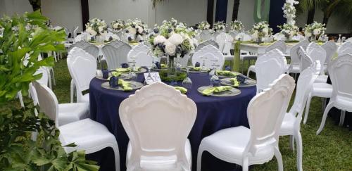 a table with white chairs and a blue table cloth at Park Springs Hotel in Cape Coast