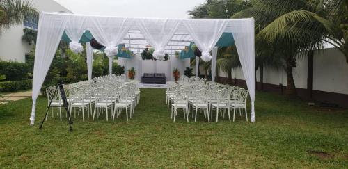 a set of tables and chairs with a white canopy at Park Springs Hotel in Cape Coast