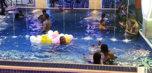 a group of people in a swimming pool with balloons at Park Springs Hotel in Cape Coast