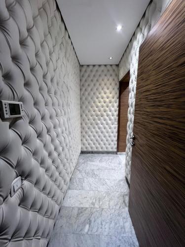 a hallway with a wooden door and a wall at Villa piscine in Temara