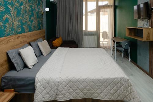 a bedroom with a large bed with blue walls at Hotel Graif Ti in Tbilisi City