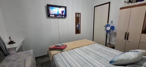une chambre avec un lit et une télévision au mur dans l'établissement Brachil 1, à Búzios