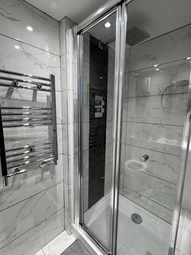 a shower with a glass door in a bathroom at Luxury 2Bed, 2Bath Flat in Greenwich London in Woolwich