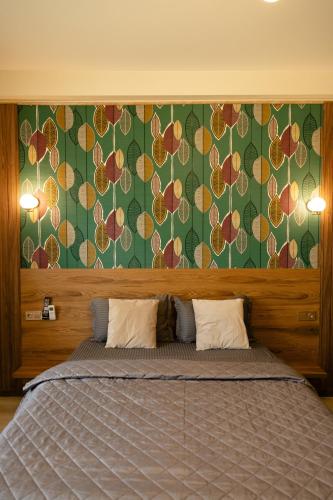 a bedroom with a large bed with a green wall at Hotel Graif Ti in Tbilisi City