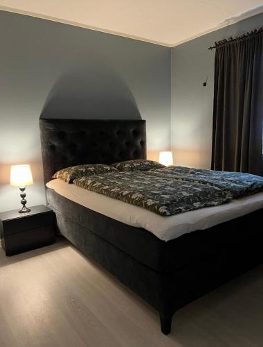 a large bed in a bedroom with two lamps at Wonderful Seaview Apartment in Tromsø