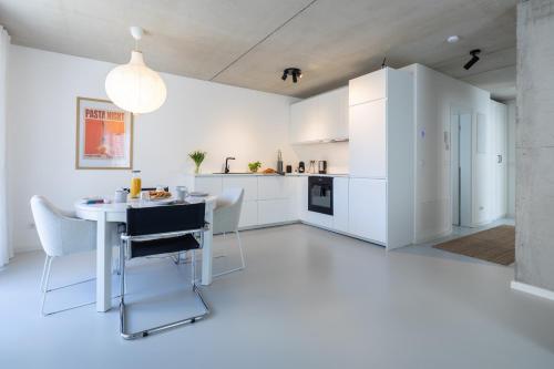 a kitchen with white cabinets and a table and chairs at Weinberg-Design-Apartment Stuttgart-Fellbach in Fellbach