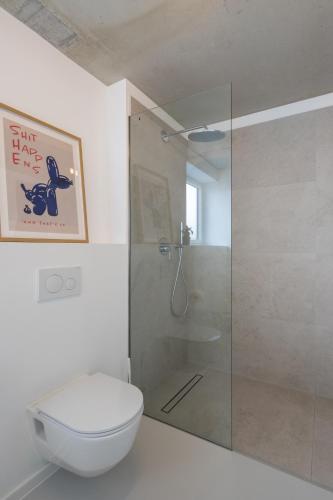 a bathroom with a toilet and a glass shower at Weinberg-Design-Apartment Stuttgart-Fellbach in Fellbach