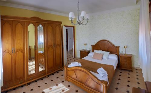 a bedroom with a bed and wooden furniture and a chandelier at Casa con vistas al mar, playa 300 m, parking, wifi in Ribeira