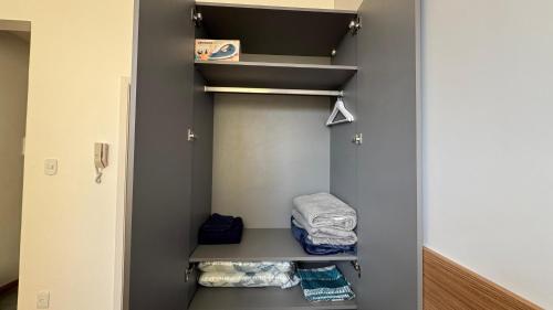 a walk in closet with a shelf and towels at Loft Sofisticado no Bairro Alto - Teresópolis in Teresópolis