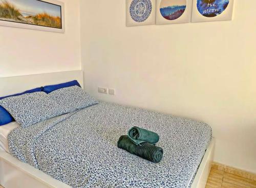 Un dormitorio con una cama con una almohada verde. en Lindo estudio en Martiánez, en Puerto de la Cruz