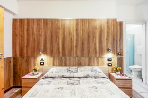 a bedroom with a large bed with a wooden wall at Villa Trieste in Marghera