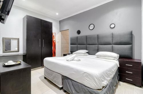 ヨハネスブルグにあるHunni Hotel Melrose Edgeの大きなヘッドボード付きの大きなベッドのある寝室