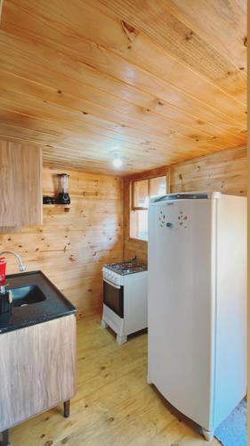 a kitchen with a refrigerator and a stove at Cabanas da Faby in Canela