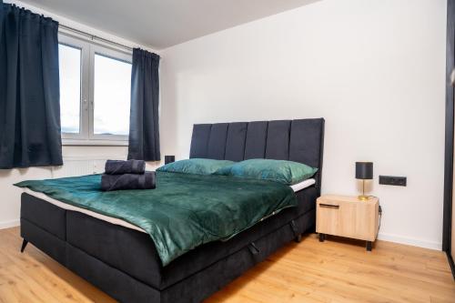 a bedroom with a large bed with a black headboard at Luxapartment l Krivá in Košice
