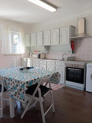 a kitchen with a table and a stove top oven at Villa Gonçalo in Caldas da Rainha
