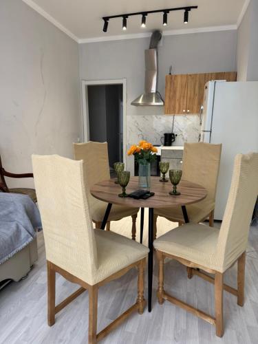 a kitchen and dining room with a wooden table and chairs at Квартиры апартаменты посуточно in Astana