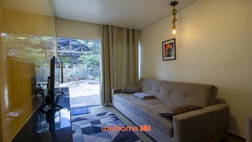 a living room with a couch and a large window at Chale em Serra Negra com vista para montanha in Bezerros