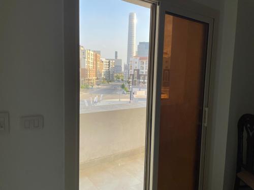 eine offene Tür zu einem Fenster mit Blick auf eine Stadt in der Unterkunft Apartment, New Administrative Capital in Madīnat al Amal