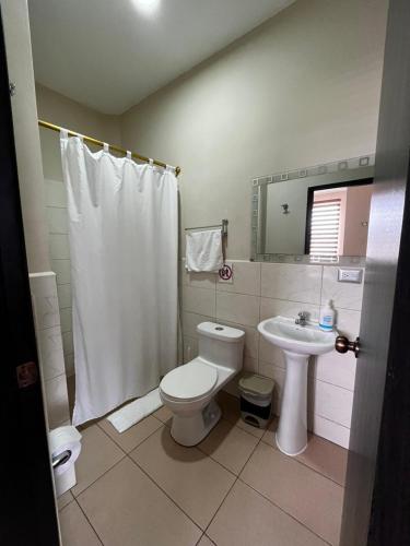 a bathroom with a toilet and a sink at Dreams Studios & Apartments in Puerto Ayora
