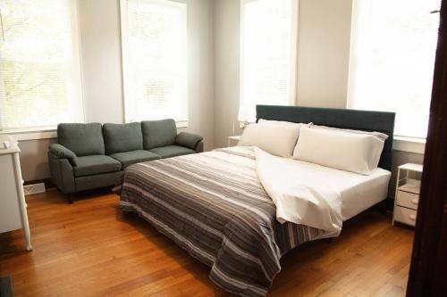 a bedroom with a bed and a couch and windows at 718 Morgan Ave in Harriman