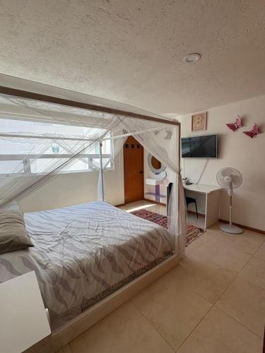 a bedroom with a canopy bed and a desk at Luxurious house in Puebla in Tlazcalancingo