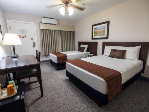 a hotel room with two beds and a desk at Stovepipe Wells Village in Death Valley