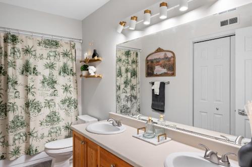 a bathroom with a sink and a toilet and a mirror at Lovely 1 BR APT in Moncton